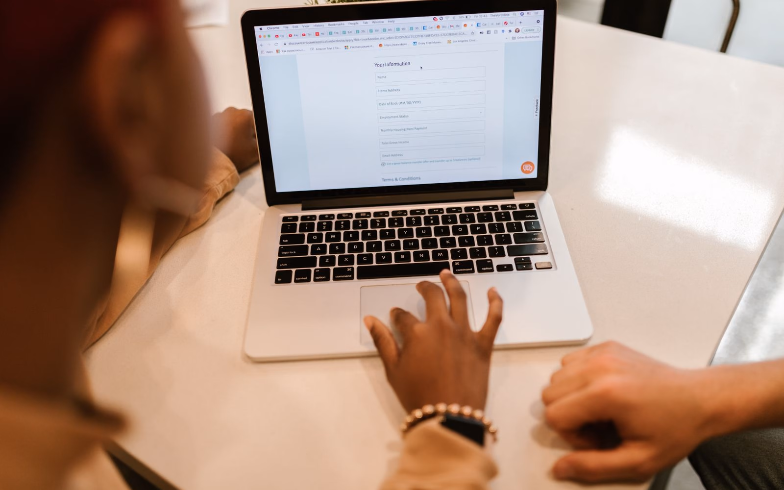 Two people reviewing a lead qualification form on a laptop